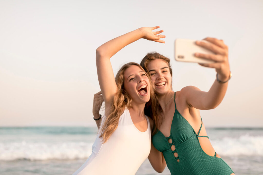 visit sithonia greece teenage-girls-taking-selfie-mobile-phone-beach